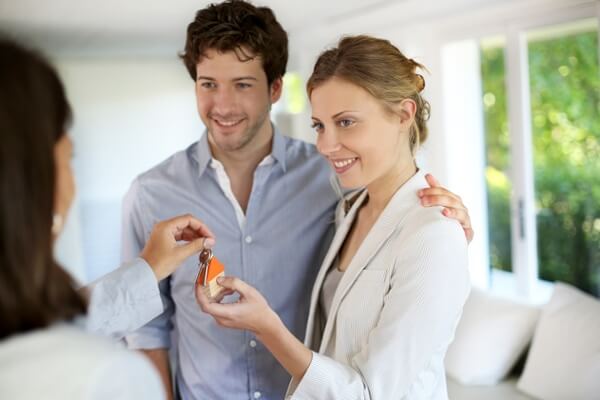 Happy young couple getting keys of their new home.jpeg